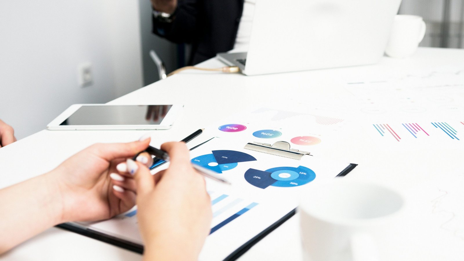 Team working on financial analysis with charts, data, and digital devices in an office setting.